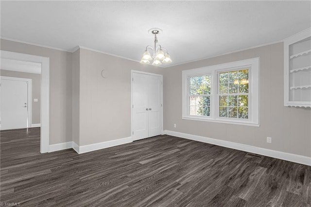 spare room with built in shelves, a chandelier, and dark hardwood / wood-style floors