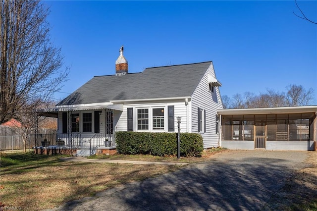 back of property featuring a lawn and a sunroom