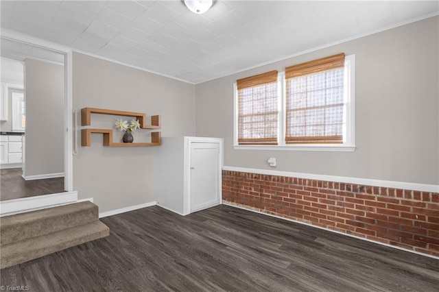 spare room featuring ornamental molding and dark wood-type flooring