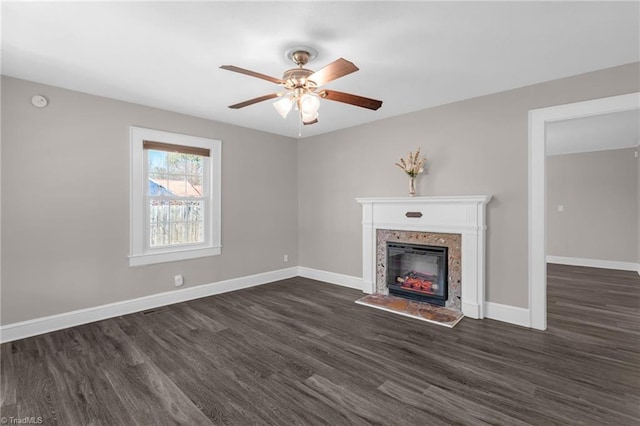 unfurnished living room featuring dark hardwood / wood-style flooring and ceiling fan