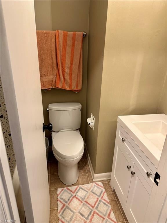 bathroom with tile patterned flooring, vanity, and toilet