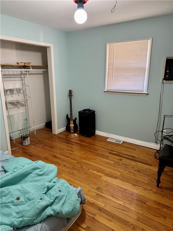 bedroom with ceiling fan, a closet, and hardwood / wood-style flooring