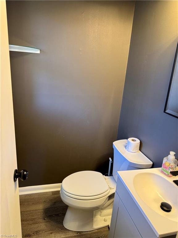 bathroom with hardwood / wood-style floors, vanity, and toilet