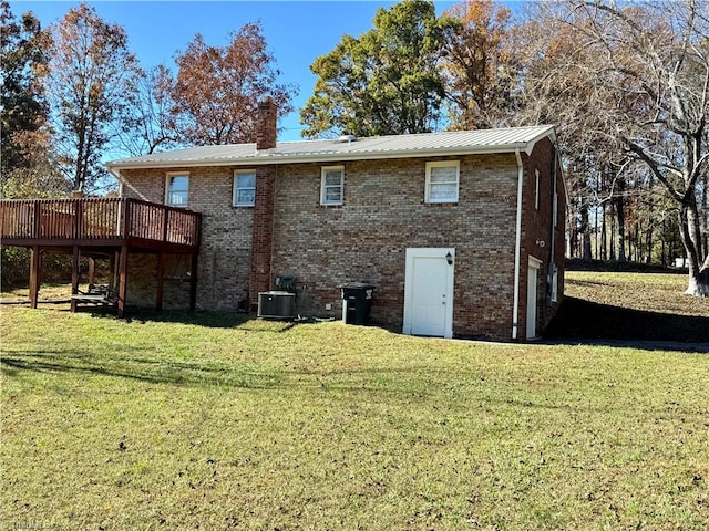 rear view of house with a yard, a deck, and central air condition unit