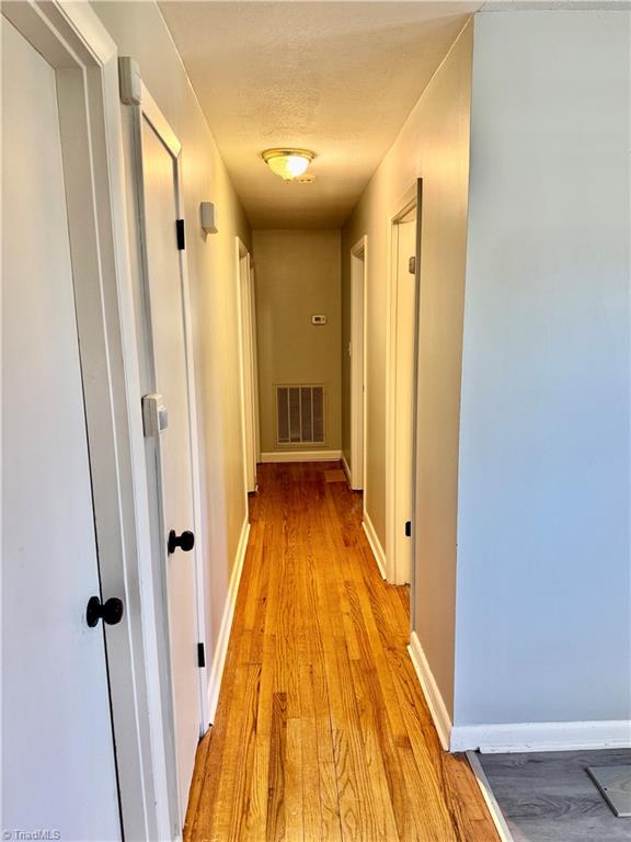 corridor with light hardwood / wood-style floors