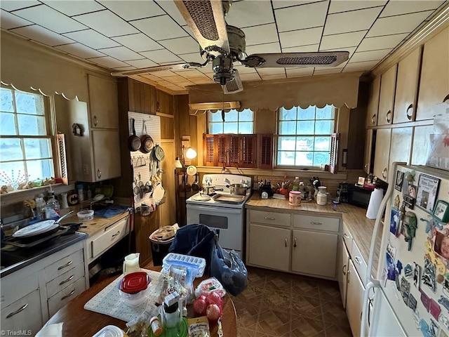 kitchen featuring wood walls, white appliances, light countertops, and ceiling fan