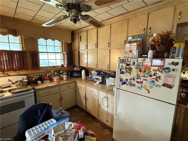 kitchen featuring white appliances, light countertops, a ceiling fan, and dark tile patterned flooring