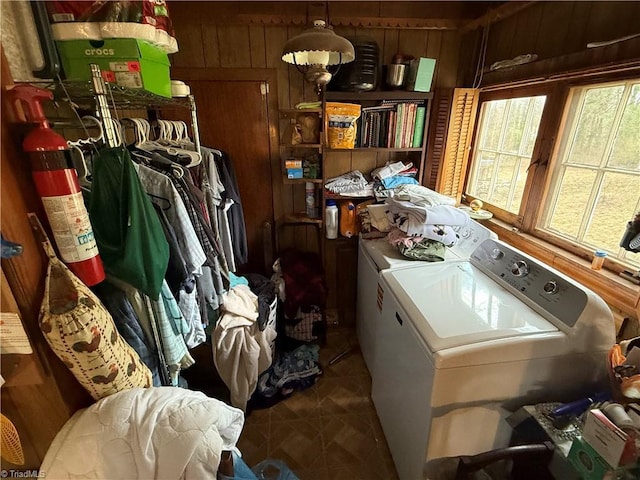 laundry room featuring washer and dryer, wood walls, and laundry area