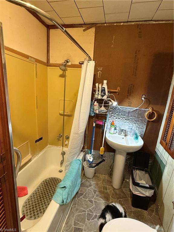 full bathroom featuring a drop ceiling and shower / bath combo