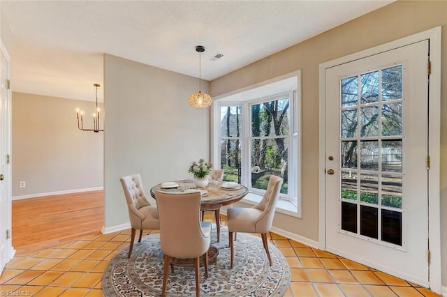 dining space with a wealth of natural light, a chandelier, and light tile patterned flooring