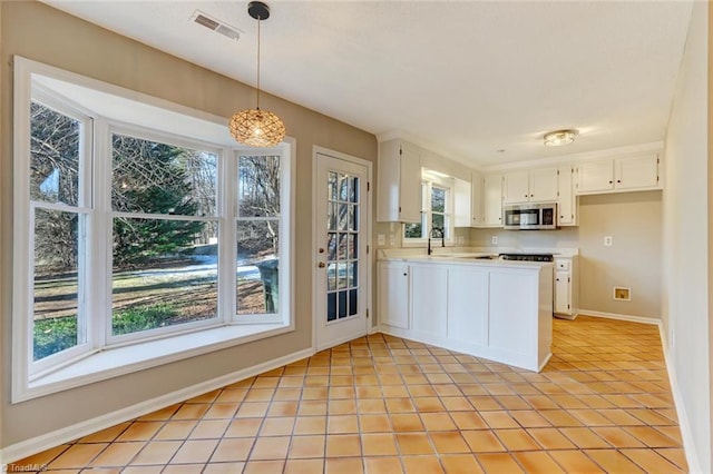 kitchen with light tile patterned floors, sink, pendant lighting, and white cabinets