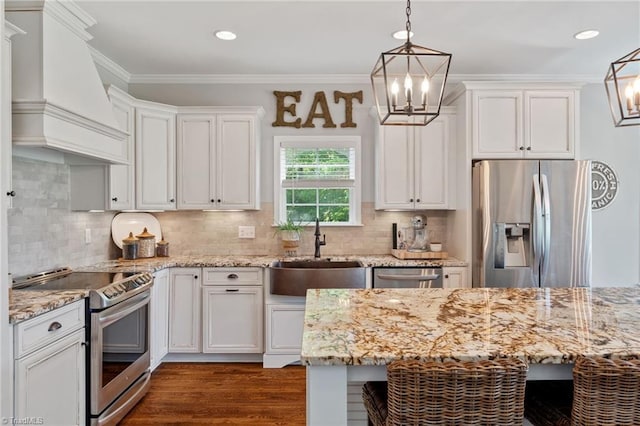 3922 Tam O Shanter Rd, Kernersville, NC 27284 - kitchen featuring appliances with stainless steel finishes, premium range hood, a chandelier, white cabinetry, and crown molding
