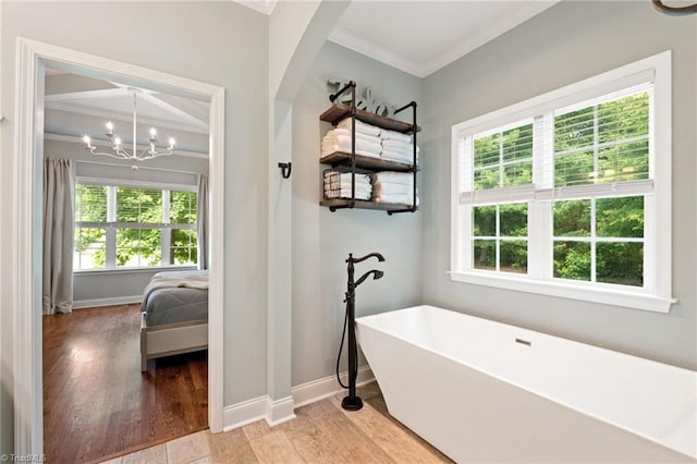 3922 Tam O Shanter Rd, Kernersville, NC 27284 - ensuite bathroom with crown molding, a soaking tub, healthy amount of natural light, wood finished floors, and a chandelier