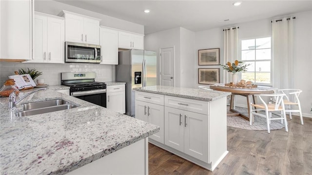 6617 Grogan Hill Rd, Whitsett, NC 27249 - kitchen featuring appliances with stainless steel finishes, a sink, a kitchen island, white cabinets, and recessed lighting