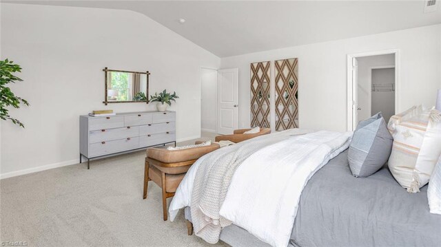 6617 Grogan Hill Rd, Whitsett, NC 27249 - bedroom with vaulted ceiling, baseboards, light carpet, and a walk in closet