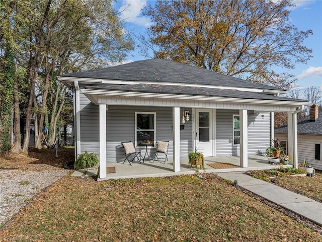 bungalow-style house with a front lawn and covered porch