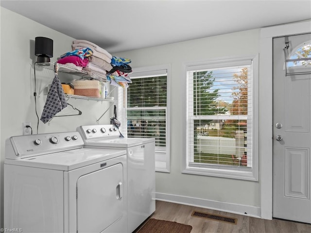 washroom featuring a wealth of natural light, independent washer and dryer, and light hardwood / wood-style flooring