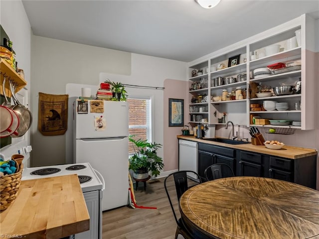 kitchen featuring wooden counters, light wood-type flooring, white appliances, and sink