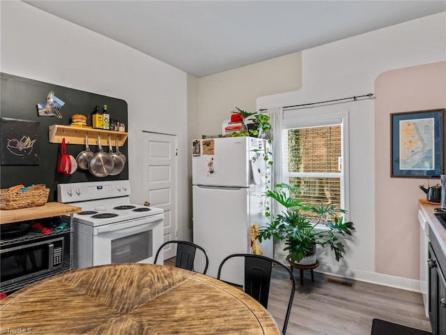 kitchen with light wood-type flooring and white appliances