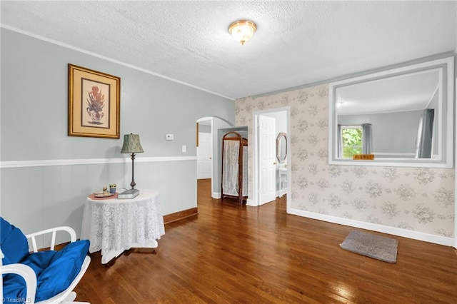 109 Easy St, Providence, NC 27315 - living area featuring arched walkways, wood finished floors, a textured ceiling, wallpapered walls, and baseboards