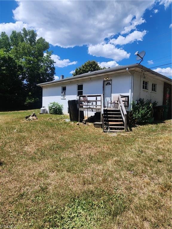 back of property with a deck and a yard