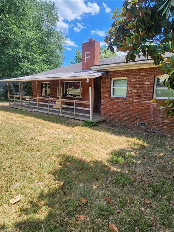 ranch-style house with a chimney and brick siding