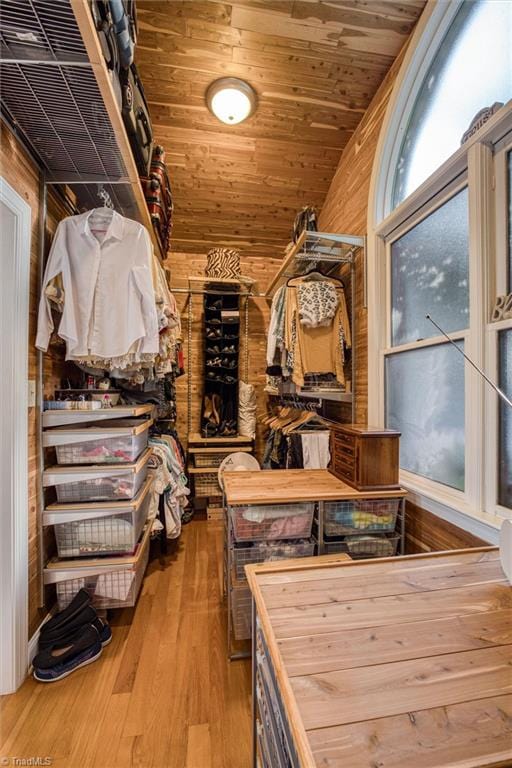 walk in closet with wood-type flooring and vaulted ceiling