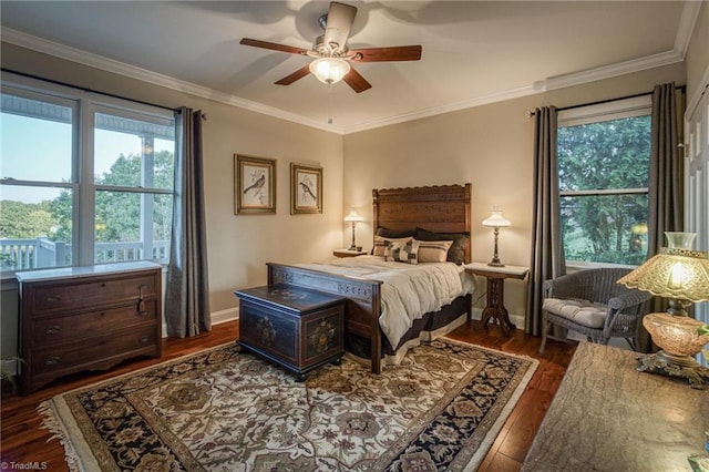 bedroom featuring dark hardwood / wood-style flooring, crown molding, and ceiling fan