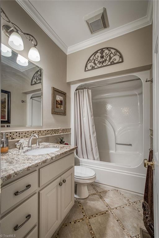 full bathroom with shower / bathtub combination with curtain, vanity, tasteful backsplash, ornamental molding, and toilet