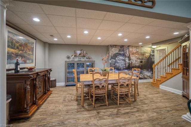 dining space featuring hardwood / wood-style floors and a drop ceiling