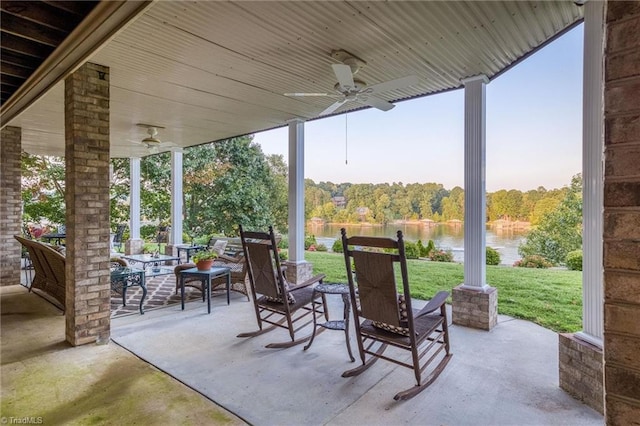 view of patio with a water view, ceiling fan, and an outdoor living space