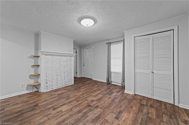 unfurnished living room with dark hardwood / wood-style flooring, ornamental molding, and a textured ceiling