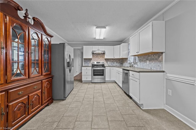 kitchen featuring sink, light tile patterned floors, appliances with stainless steel finishes, white cabinetry, and tasteful backsplash