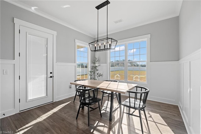 dining room with dark hardwood / wood-style flooring, an inviting chandelier, and ornamental molding