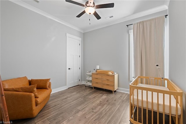 living area with hardwood / wood-style flooring, ceiling fan, and ornamental molding