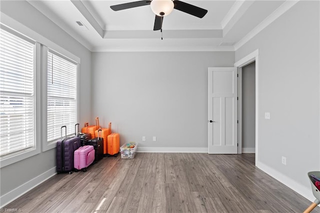 game room with a tray ceiling, a wealth of natural light, hardwood / wood-style floors, and crown molding