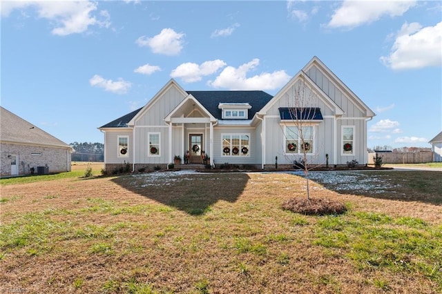 view of front of home with central AC unit and a front yard