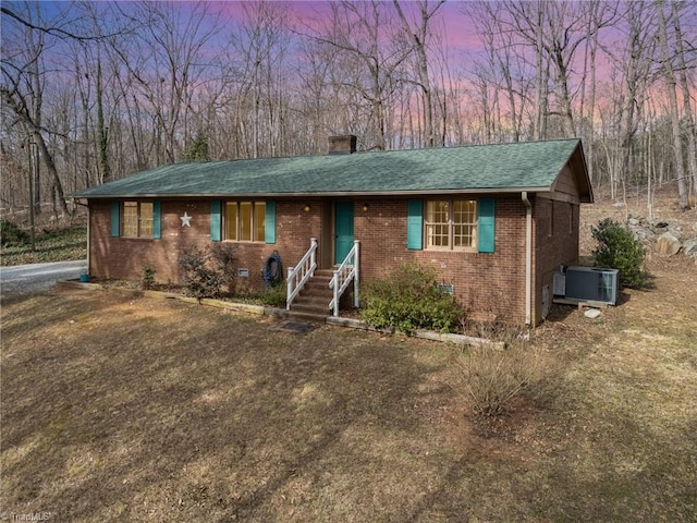 ranch-style house featuring brick siding, roof with shingles, a chimney, central air condition unit, and crawl space