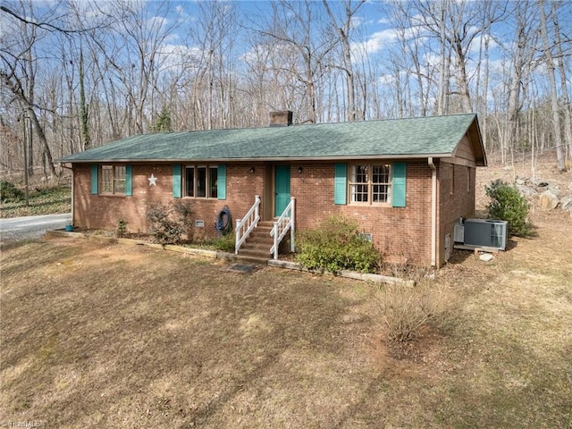 ranch-style house with cooling unit, brick siding, a shingled roof, crawl space, and a chimney