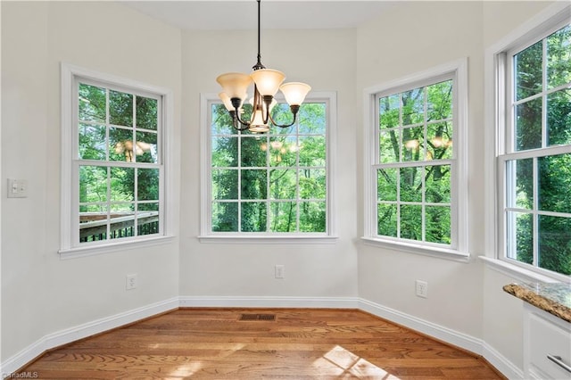 833 E Country Club Rd, Mount Airy, NC 27030 - unfurnished dining area with a chandelier, light wood-type flooring, and baseboards