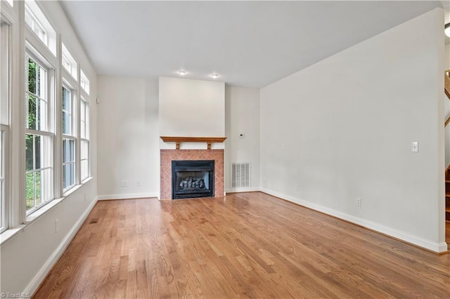 833 E Country Club Rd, Mount Airy, NC 27030 - unfurnished living room featuring light wood-type flooring, baseboards, a fireplace, and stairs