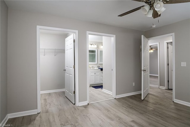 5425 Davis Rd, Walkertown, NC 27105 - unfurnished bedroom with light wood-style floors, a spacious closet, a closet, connected bathroom, and ceiling fan