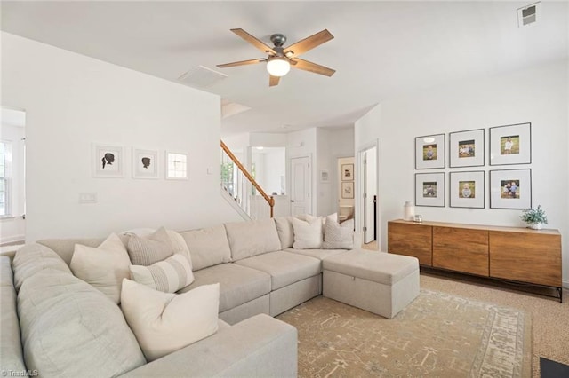 living area with visible vents, a ceiling fan, stairs, and plenty of natural light