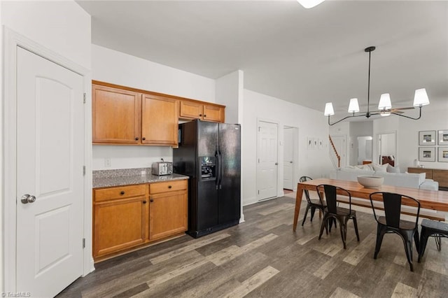 kitchen featuring decorative light fixtures, brown cabinets, an inviting chandelier, black fridge, and dark wood-type flooring