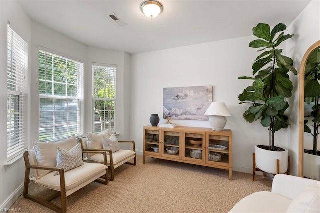 living area with baseboards, carpet flooring, and visible vents