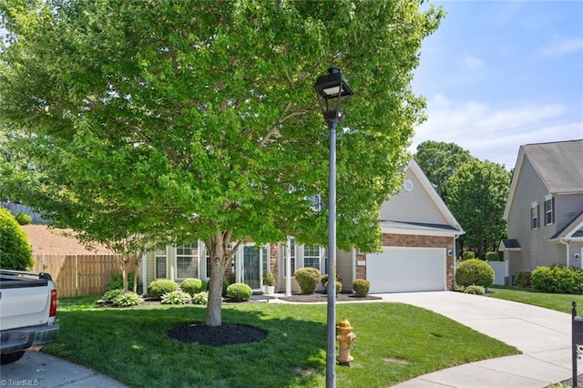 view of property hidden behind natural elements with a garage, a front lawn, fence, and concrete driveway