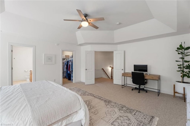 bedroom with ceiling fan, light carpet, ensuite bath, a spacious closet, and a closet