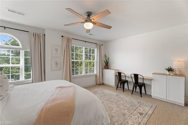 bedroom with visible vents, multiple windows, and light colored carpet