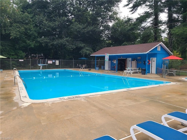 view of swimming pool featuring a patio and an outdoor structure