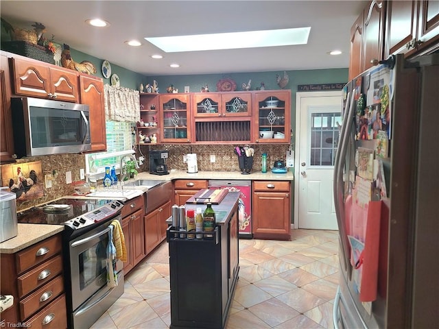 kitchen featuring a skylight, a wealth of natural light, a kitchen island, and appliances with stainless steel finishes